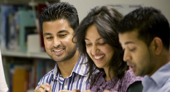 Alanoof Three students looking at a book