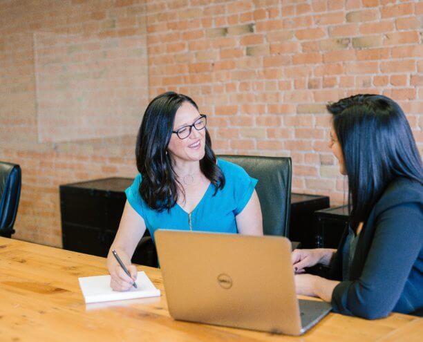 Two women at a desk.