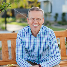 Alasdair-bio-MBA A man sitting on a bench on campus.