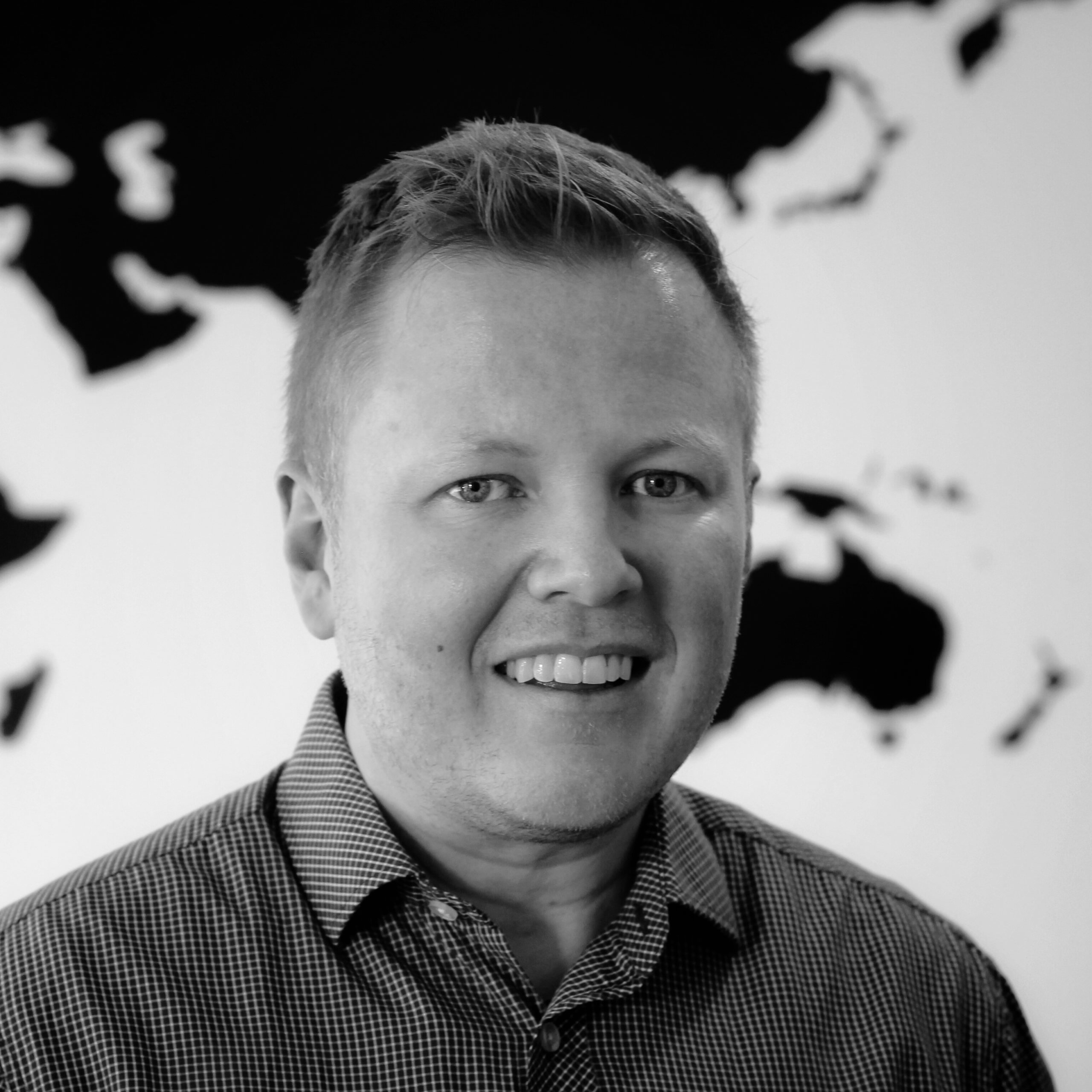 A black and white headshot profile picture of a man.