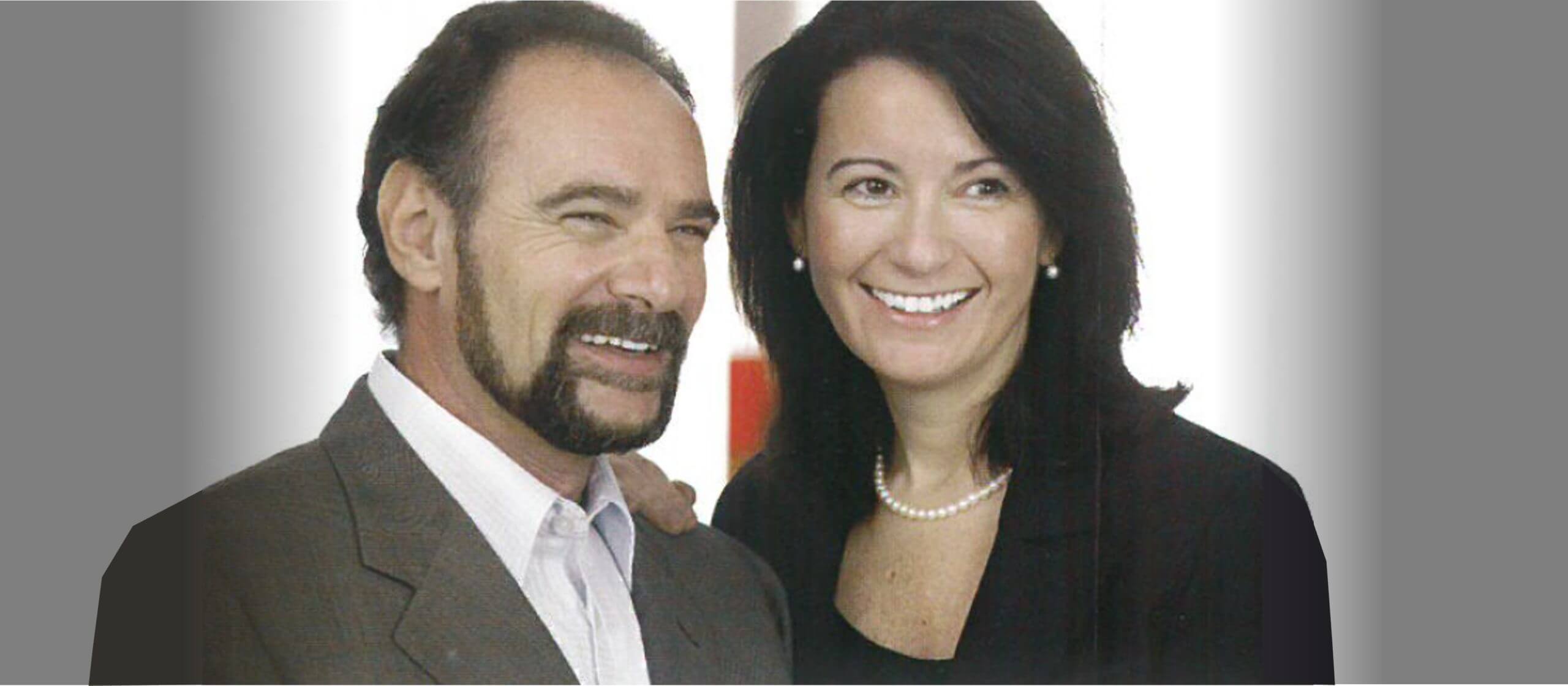 A close-up of two people standing together and smiling.