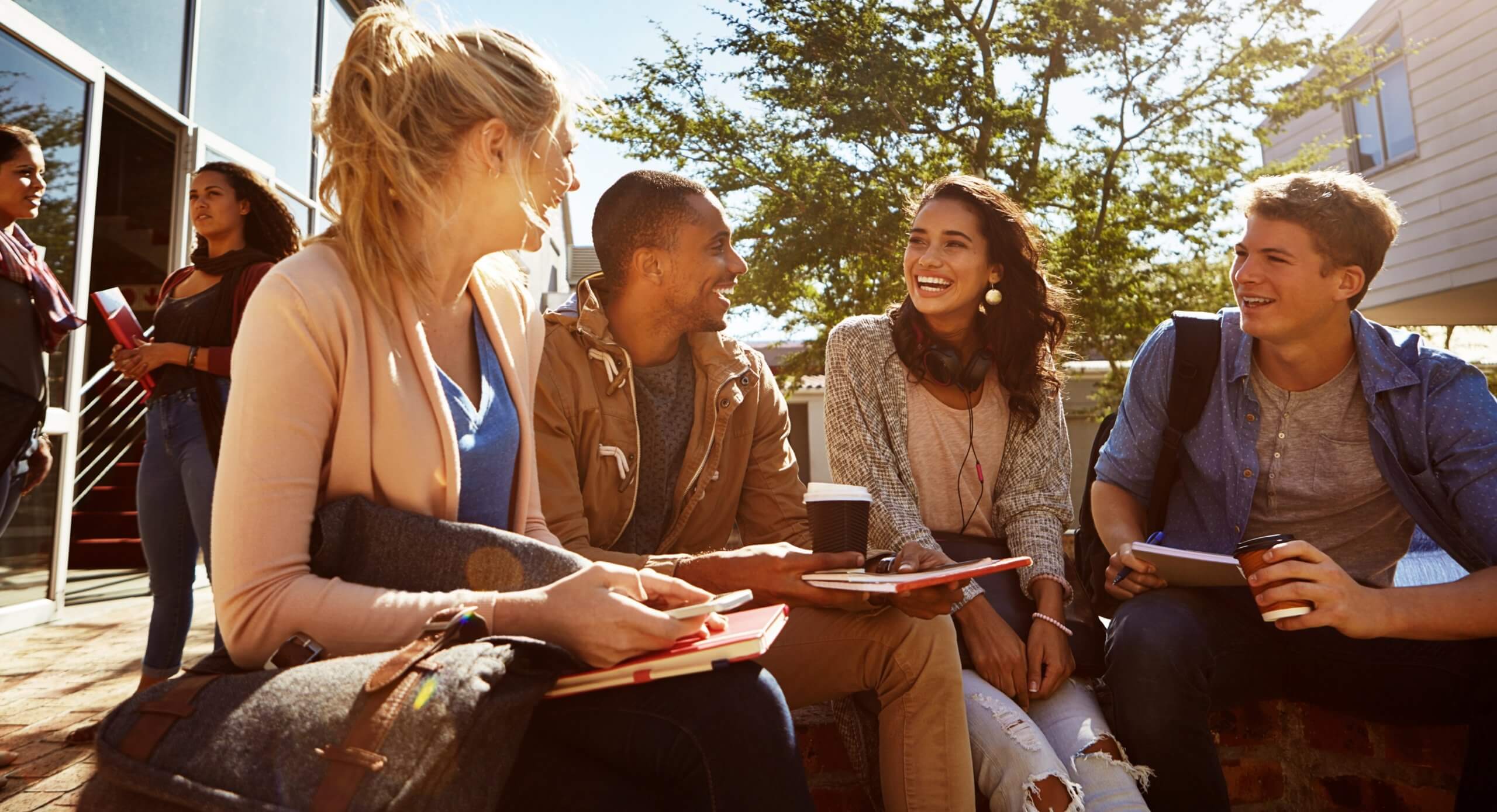 A group of students happily discuss something on campus.