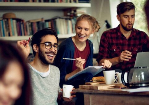 A group of students happily discuss something while sitting down.