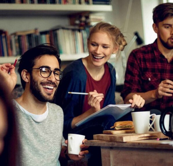 A group of students happily discuss something while sitting down.