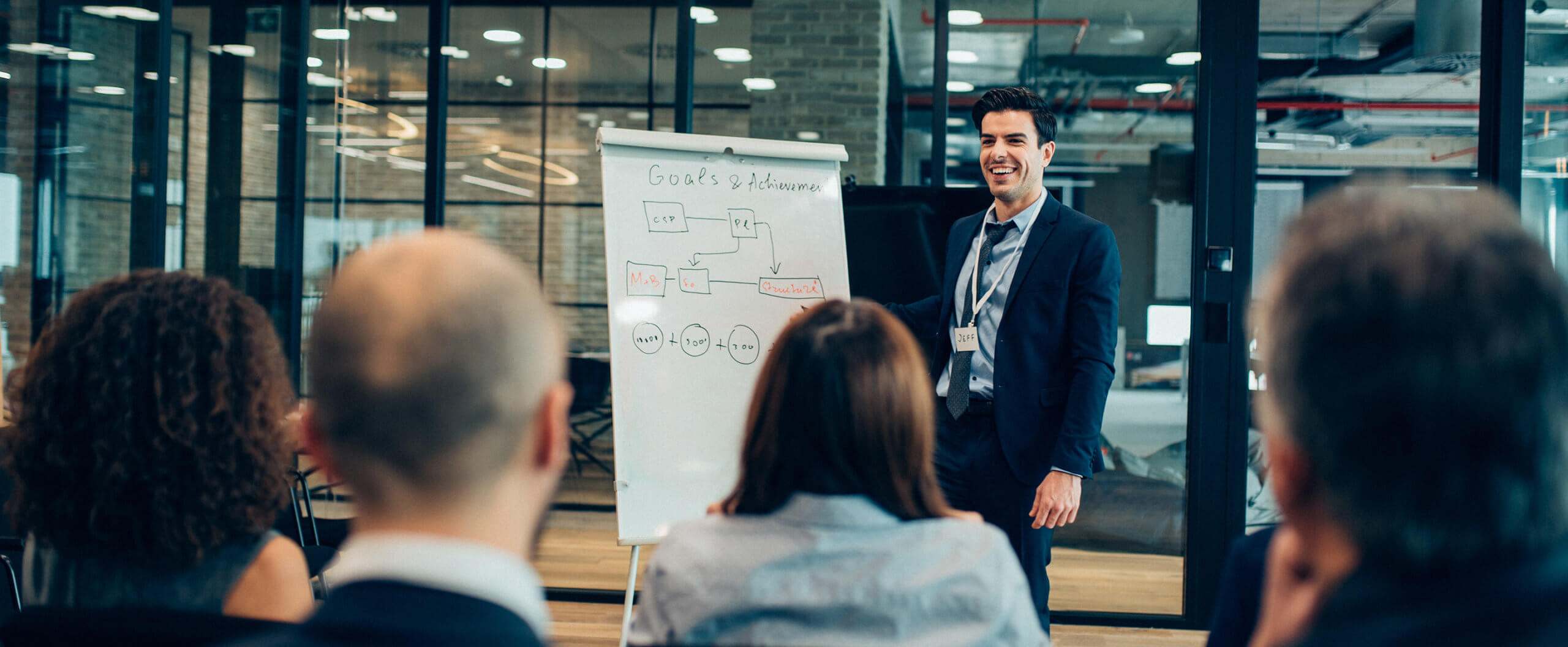 How to show your boss you're leadership potential (banner) Image of man presenting to a group of people