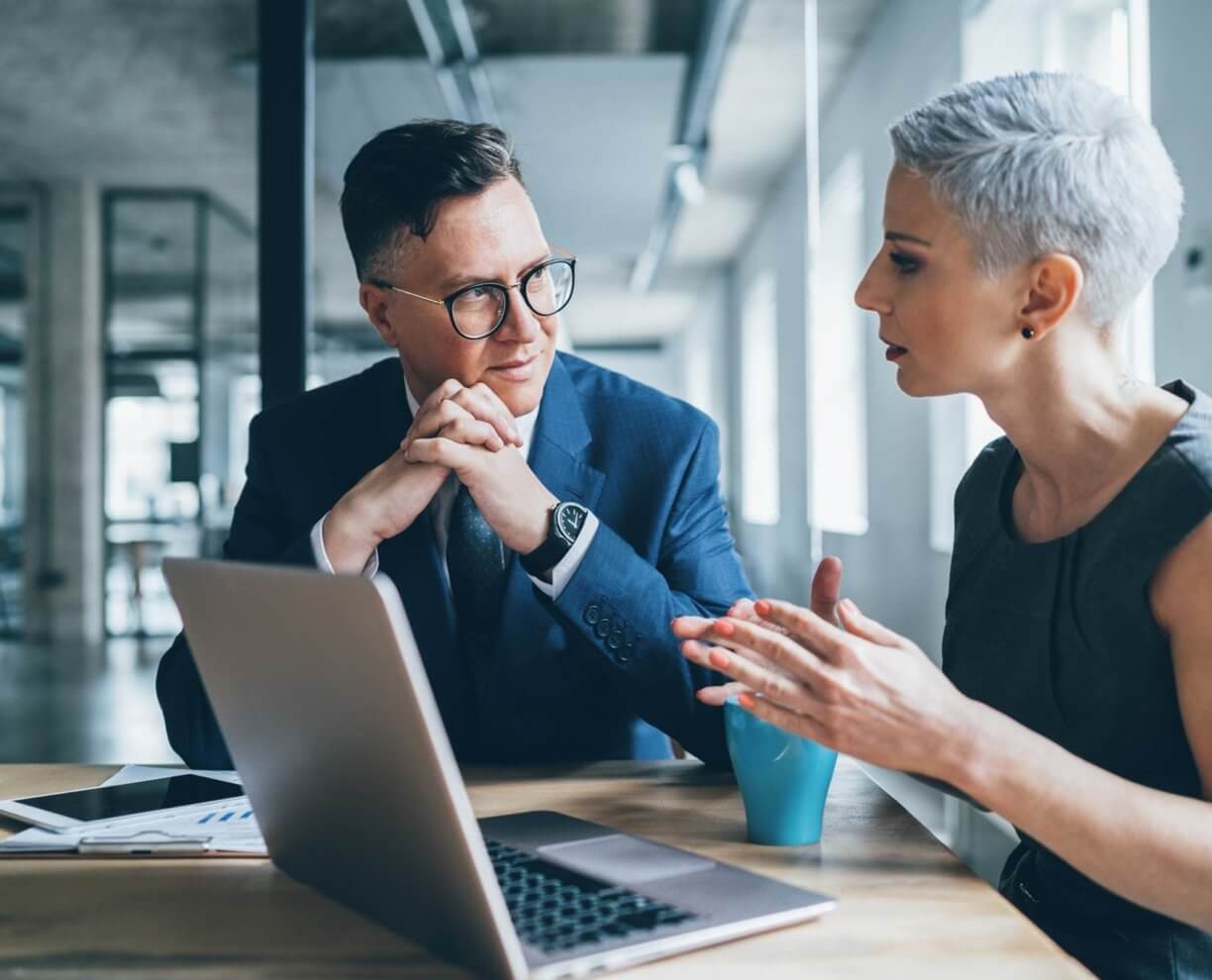 coaching A woman leading a discussion at a table.