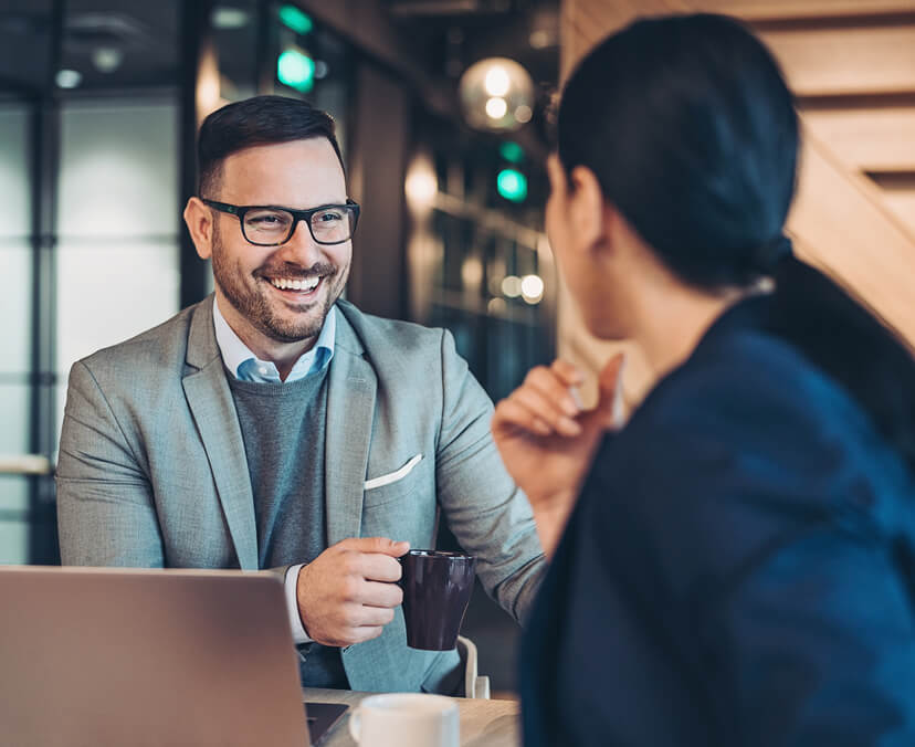 Man and woman talking over laptop