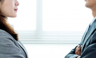 Business Close up of man and woman facing each other.