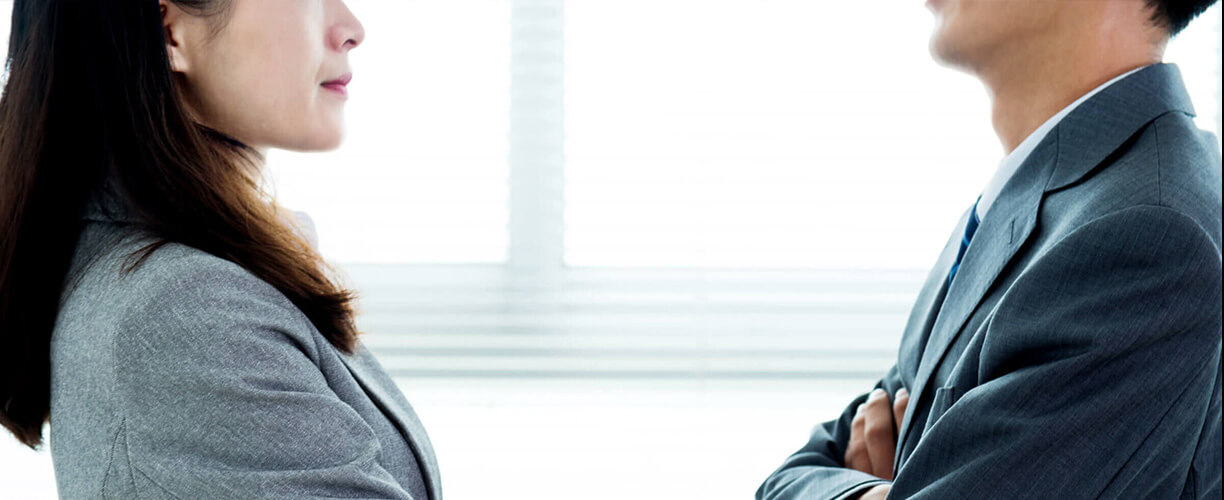 Business Close up of man and woman facing each other.