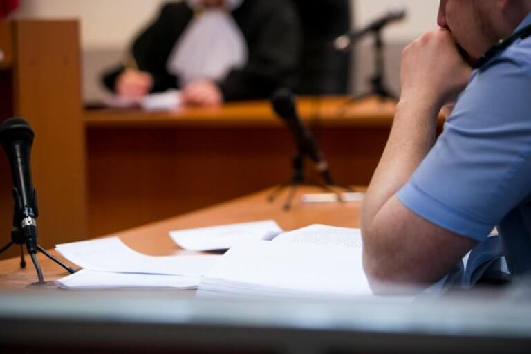 Person sitting at a desk with a microphone in front of them.