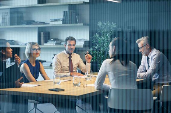 Group of work colleagues having a discussion at a desk.