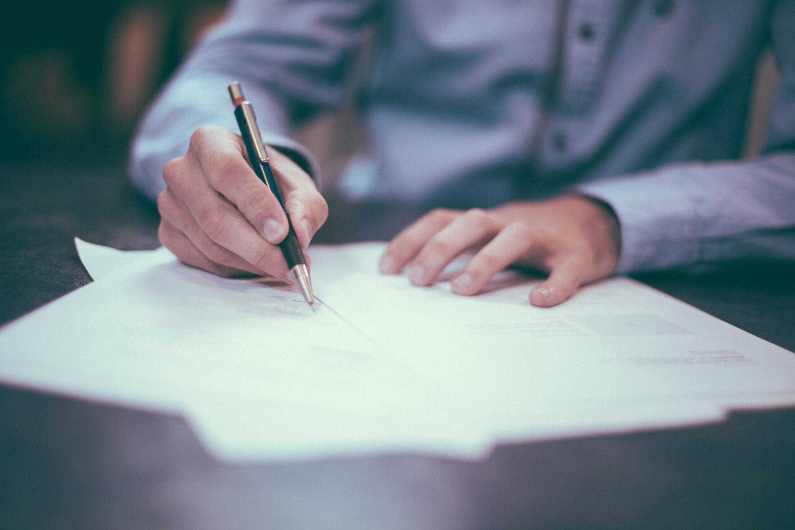 Hands writing on document