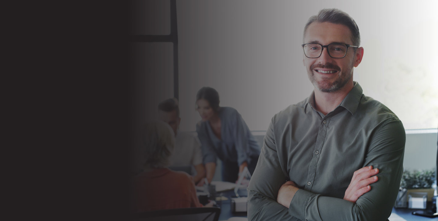 ACAP-202202281311-DiscoverACAP-April2022Sessions-DesktopBanners-Coaching-AWWeb Man smiling with crossed arms in an office