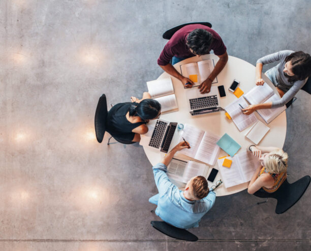Top,View,Of,Group,Of,Students,Sitting,Together,At,Table.