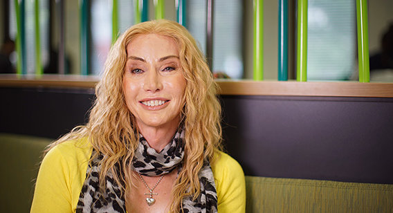 Mature blonde woman with yellow jacket and scarf