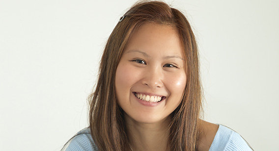 Asian woman with hair down , blue jumper and necklace