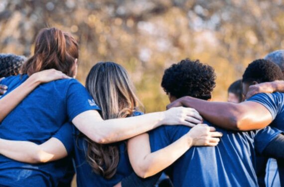 Seven people facing way embracing
