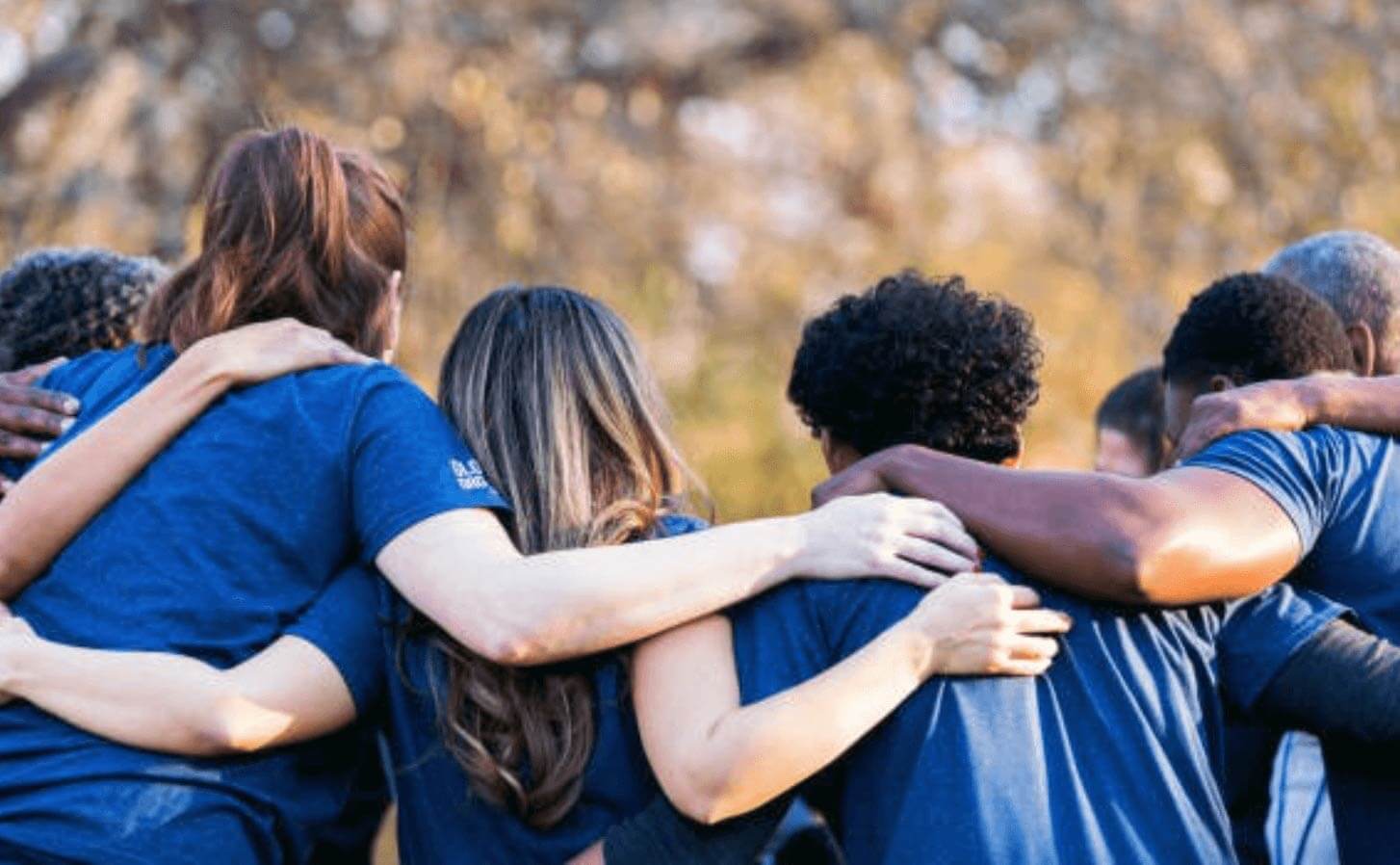 Seven people facing way embracing