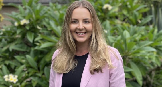 Emma, Masters of Social Work (Qualifying) Woman in front of garden in pink jacket