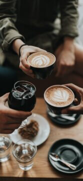 Three people holding cups of coffee