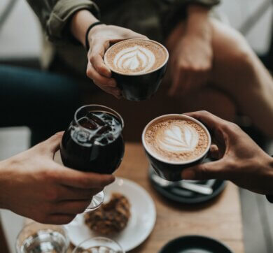 Three people holding cups of coffee