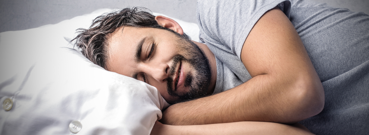 6 ways to improve your sleep A man with sleeping on a pillow with hands folded underneath it