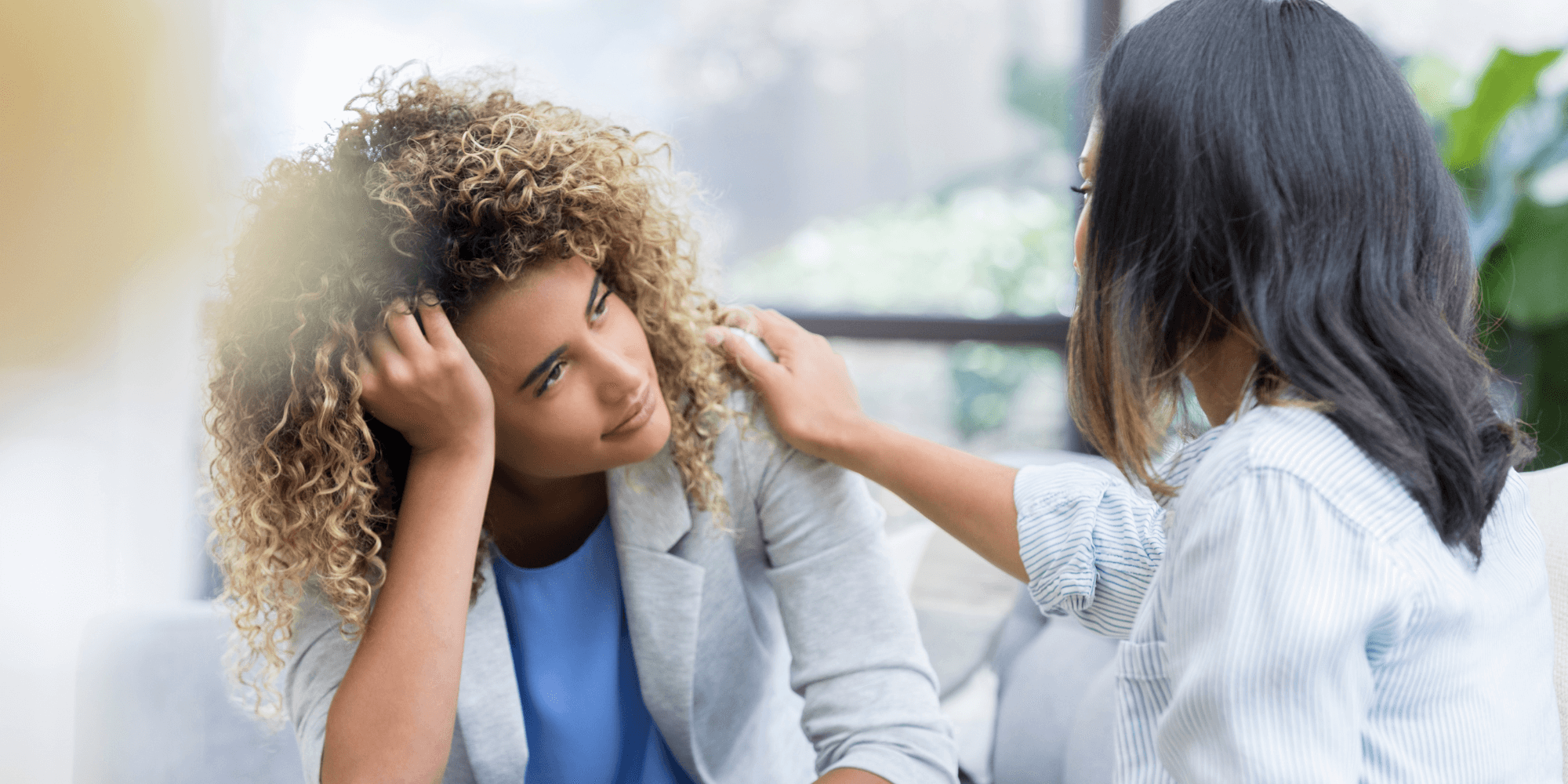 A counsellor resting her hand on a clients shoulder during a therapy session