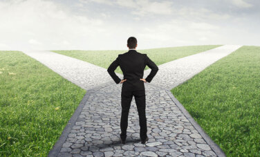 10 Tips for Career Changes A businessman with hands resting on hips facing a crossroads