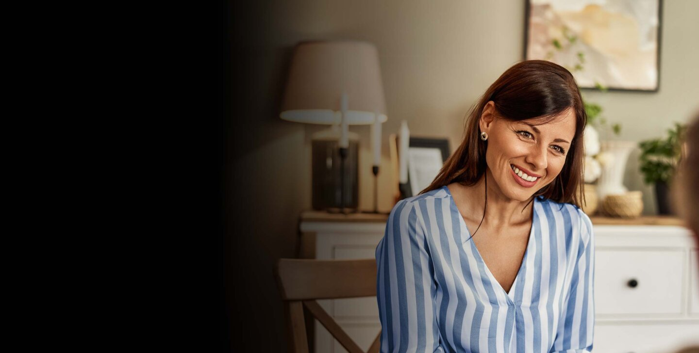 Smiling woman sitting on a chair facing towards camera, sitting across from a client