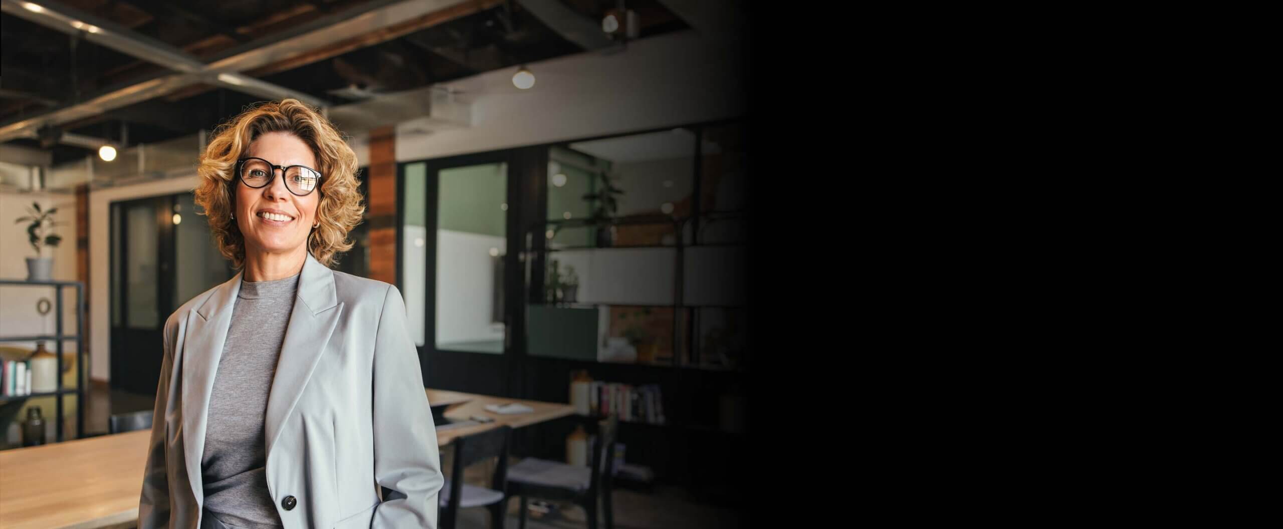 Smiling woman standing in an office, facing towards the camera