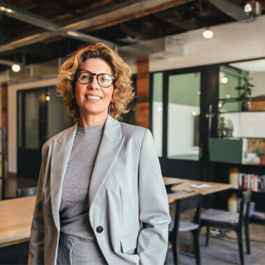 Smiling woman standing in an office, facing towards the camera