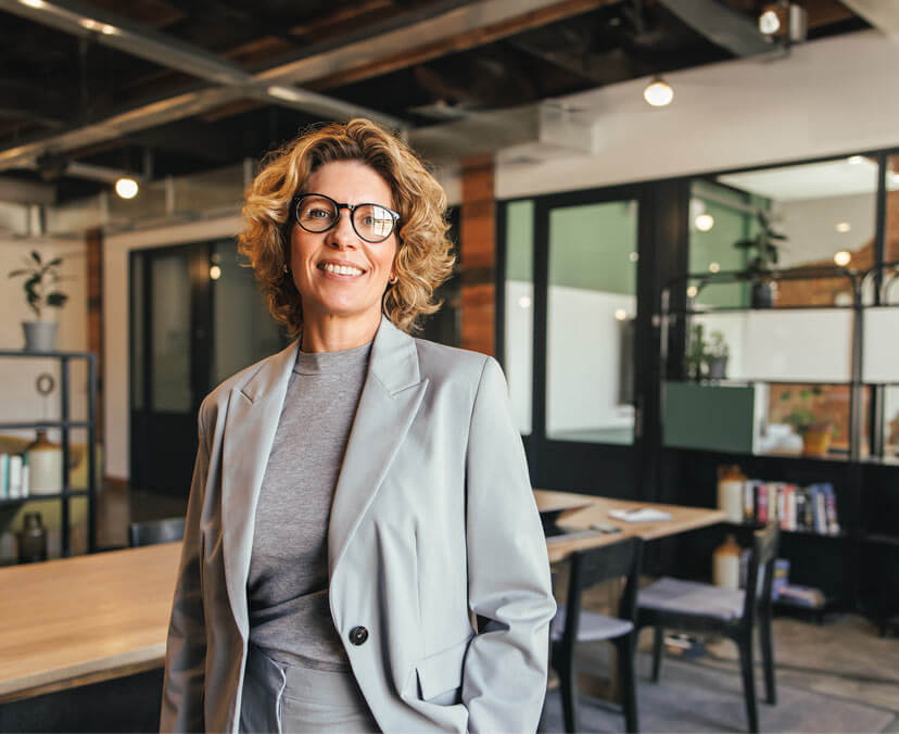 Smiling woman standing in an office, facing towards the camera