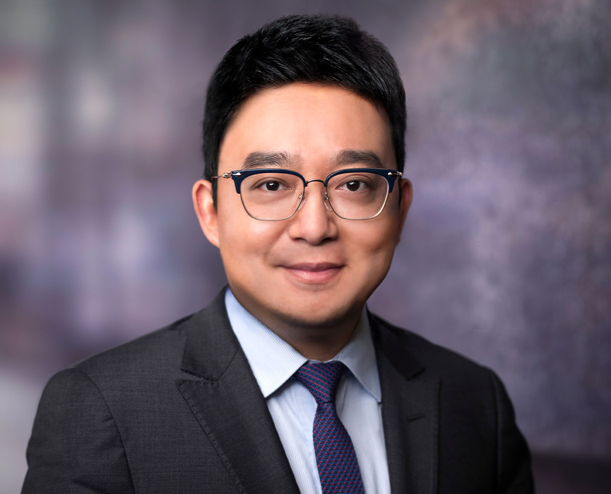 Sean Dong | ACAP alumni Portrait image of man in suit wearing glasses. Sean Dong