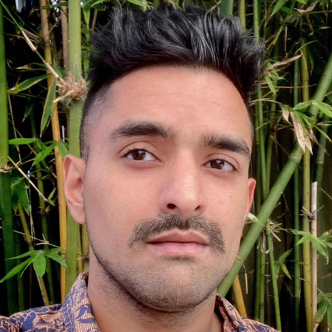 Krunal profile young man with dark skin and black hair in front of bamboo