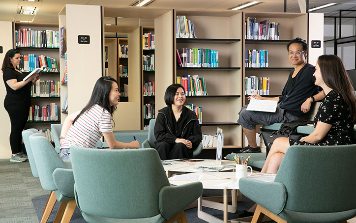 A group of students sitting in a group talking to each other at ACAP Sydney campus library - Calm & Conquer 724x454