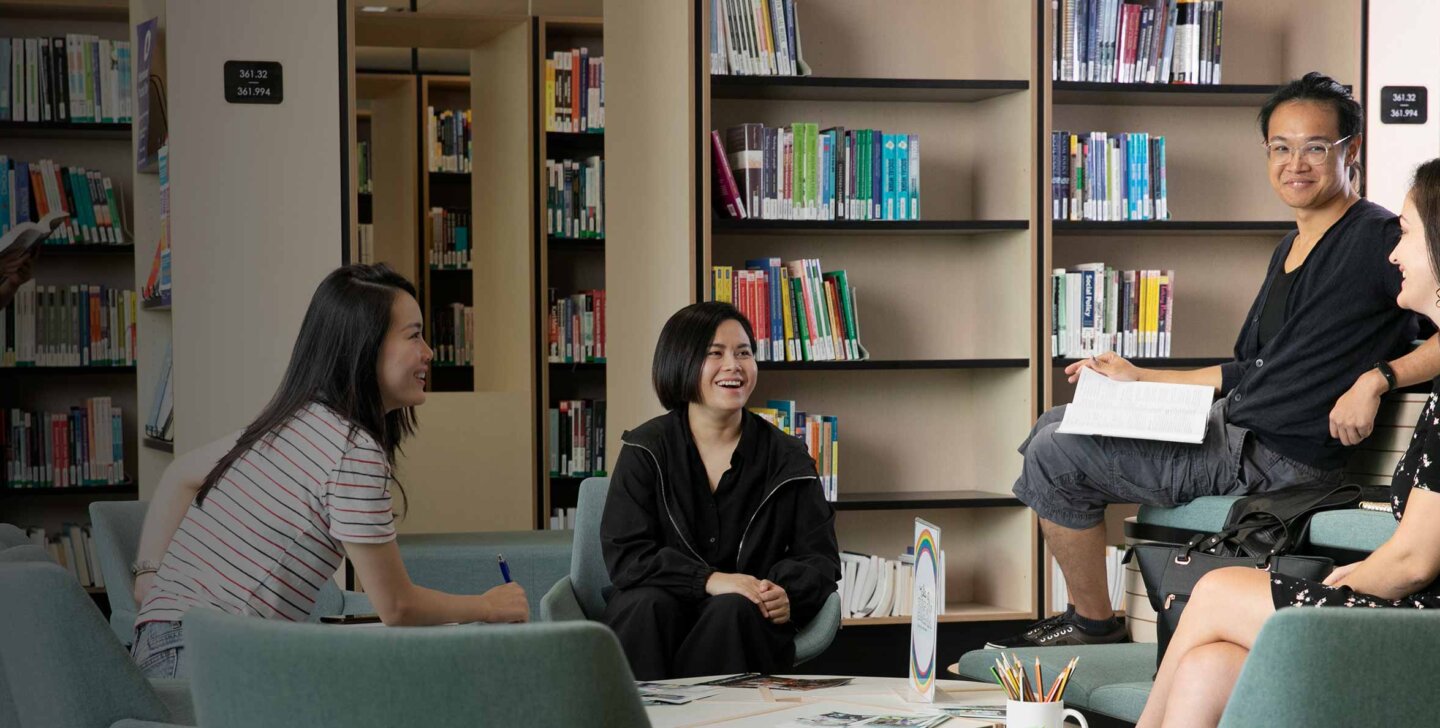 Calm-&-Conquer-header-image-desktop A group of students sitting in a group talking to each other at ACAP Sydney campus library - Calm & Conquer 2880x1188