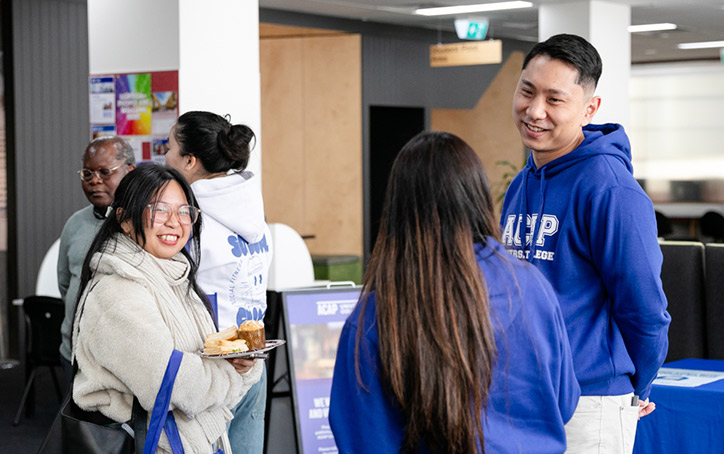 Two course advisors talking with a prospective student at an ACAP University College Open Day event (724x454)