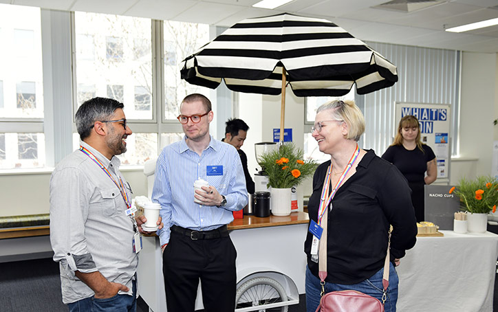 Two men and a woman standing with coffees in front of a coffee cart at an ACAP University College Open Day event (724x454)