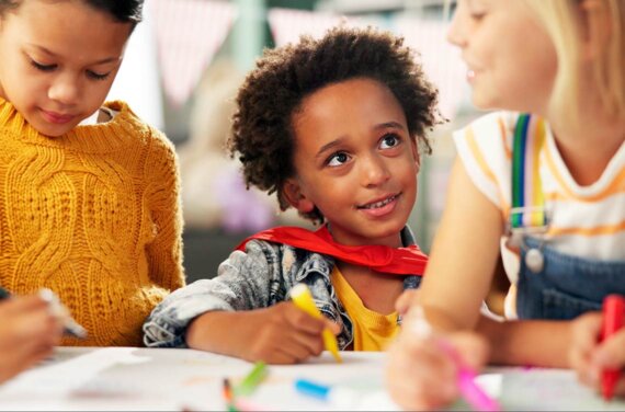 Three young girls drawing together at a table in an art class (1140x752)