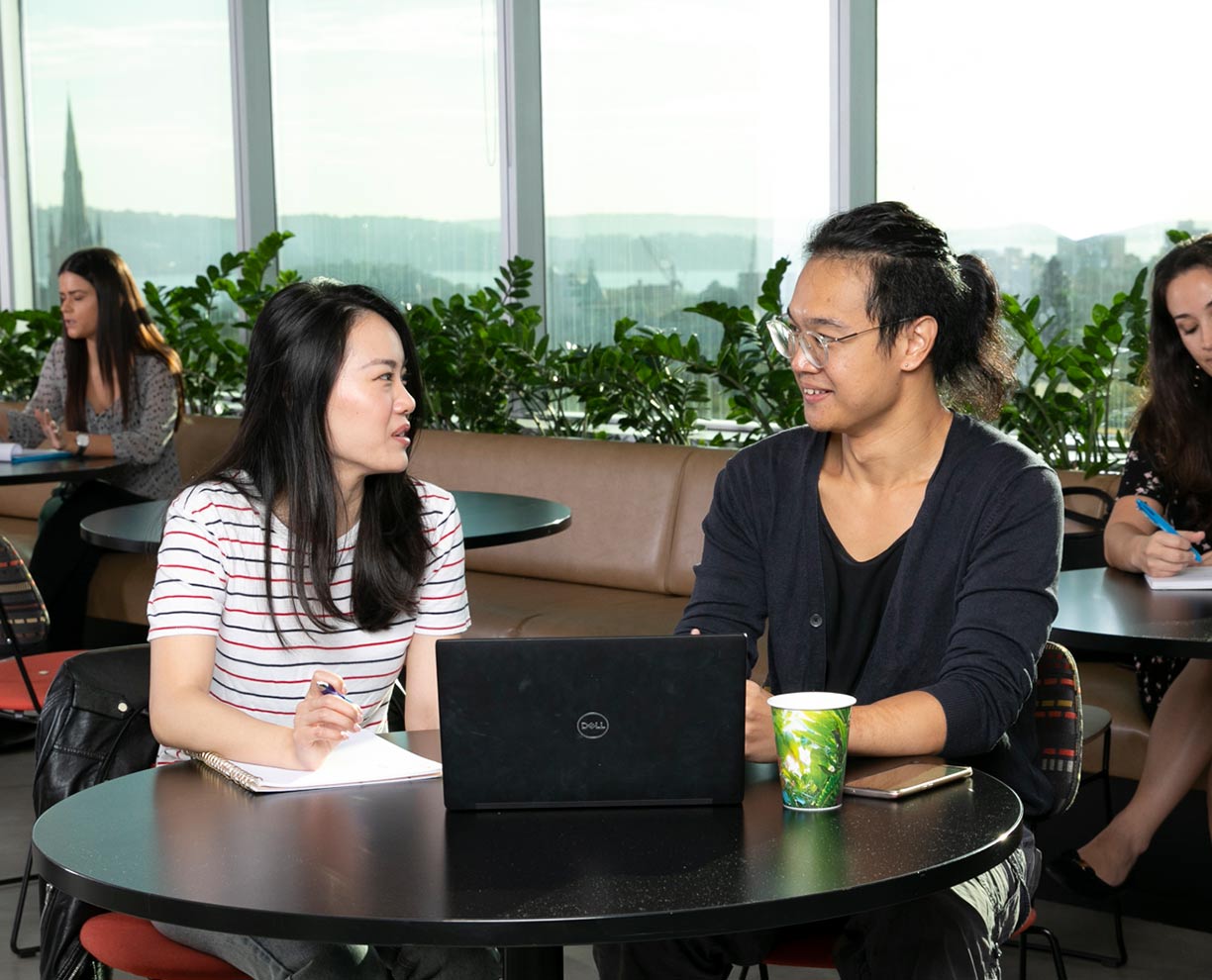 Two international students sitting at a table together at ACAP Sydney campus (1224x990)