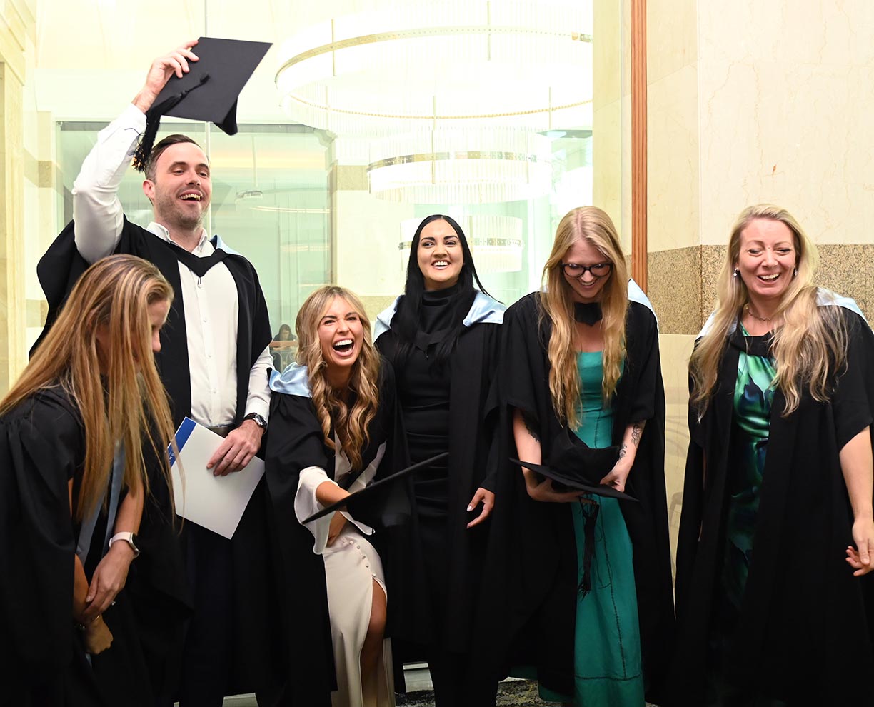 A group of ACAP alumni standing together and smiling after their graduation ceremony (1224x990)